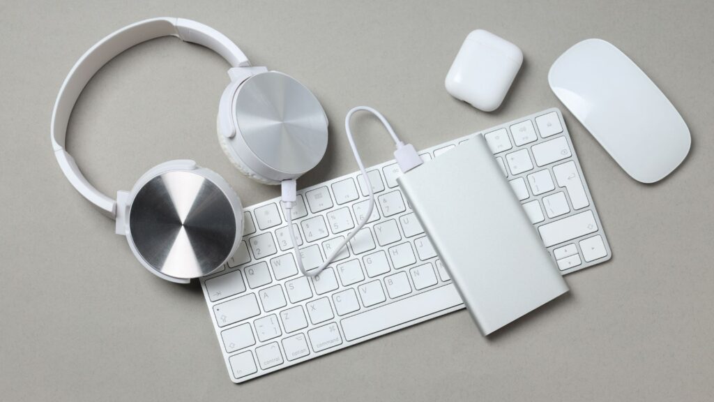 Power bank colocado con productos Mac sobre escritorio.